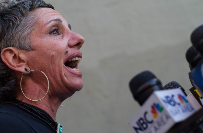 Laura Guzman, from the Mission Neighborhood Resource Center, addresses the media on Oct. 7 at a press conference, held 6 months after the shooting death of Luis Gongora Pat by the SFPD. Photo: Patricio Guillamon